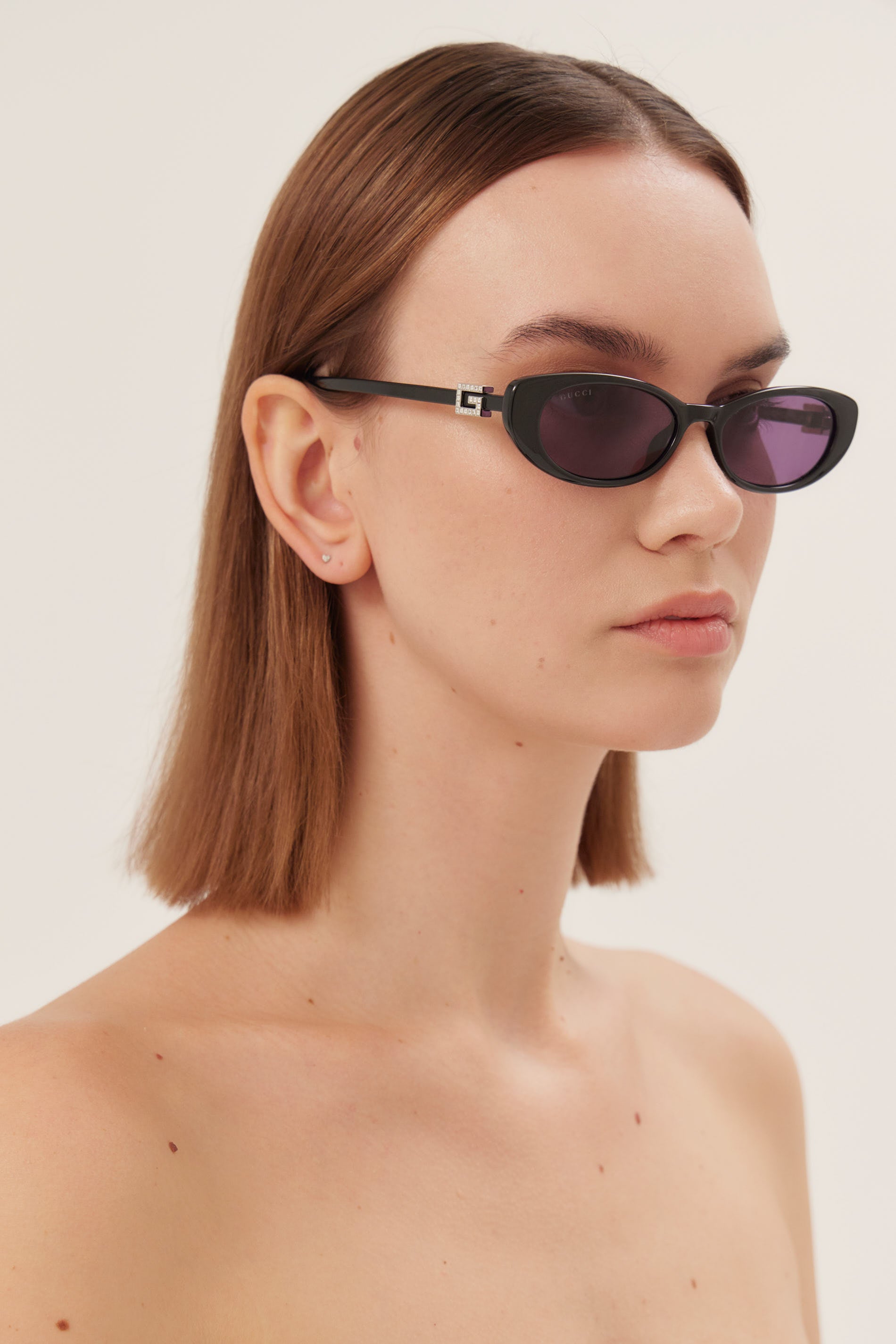 Oval cat-eye black Gucci sunglasses with bedded logo