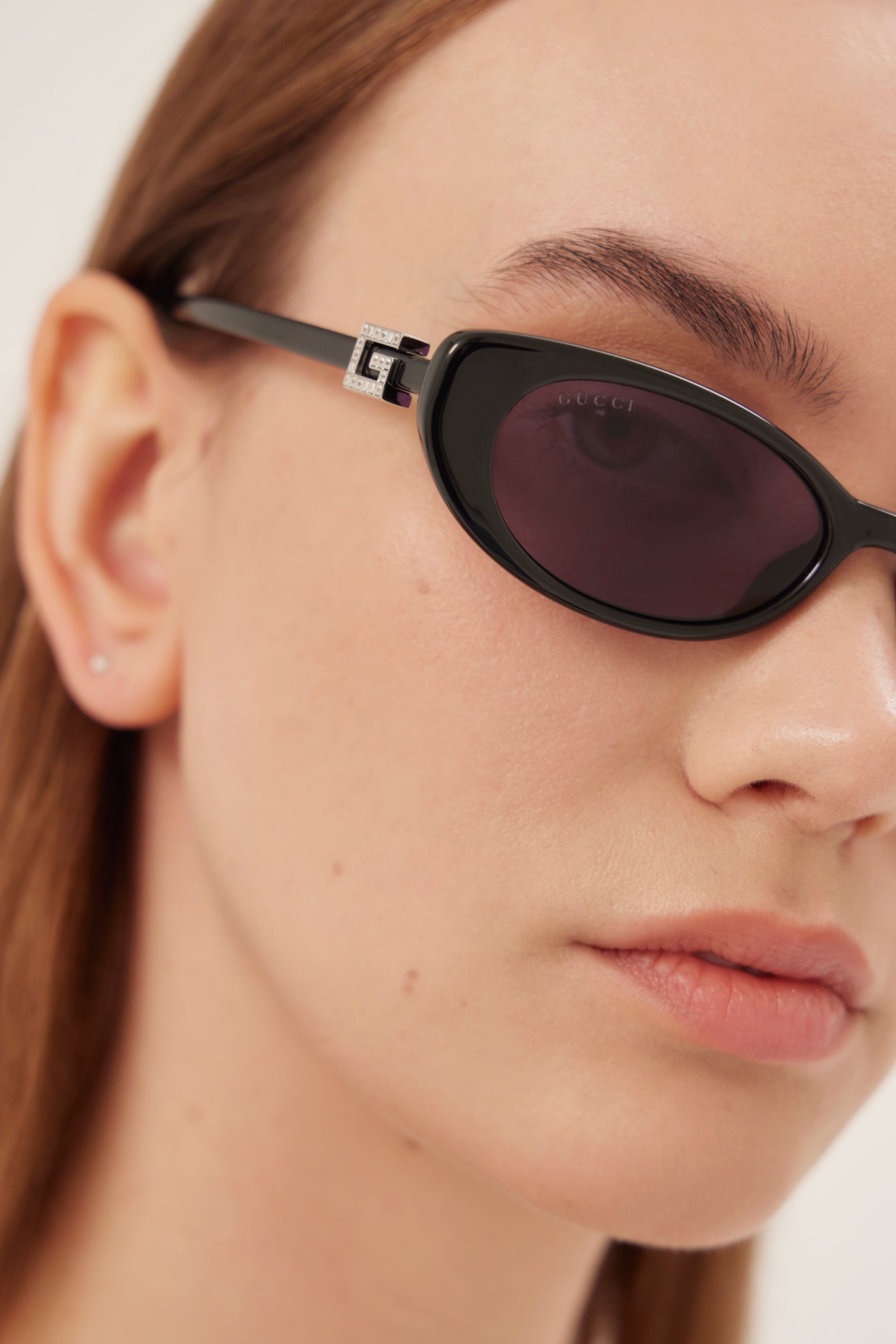 Oval cat-eye black Gucci sunglasses with bedded logo